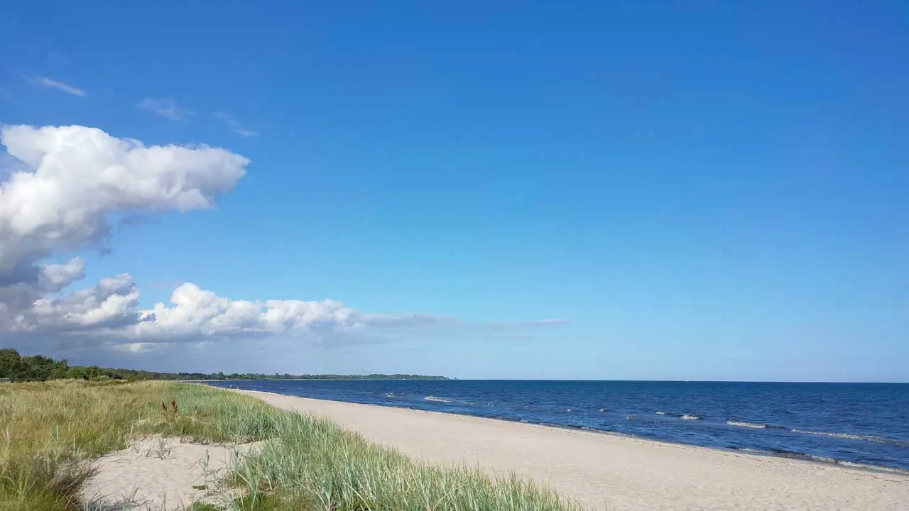 Den ljusa sandstranden vid Skateholm med Östersjön och blå himmel